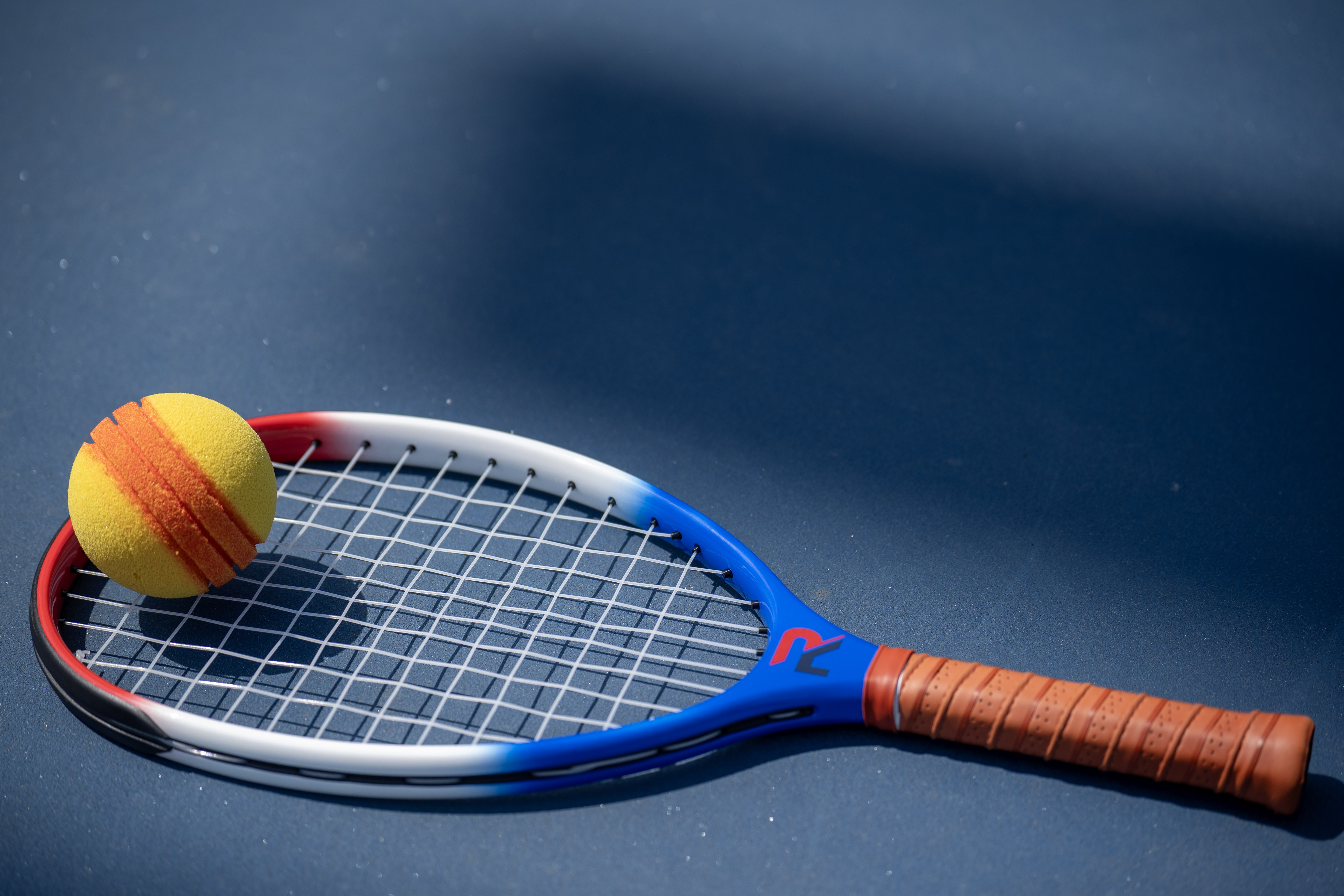 Premium red, white, and blue RALLY racket with leather grip and RALLYBALL ball
